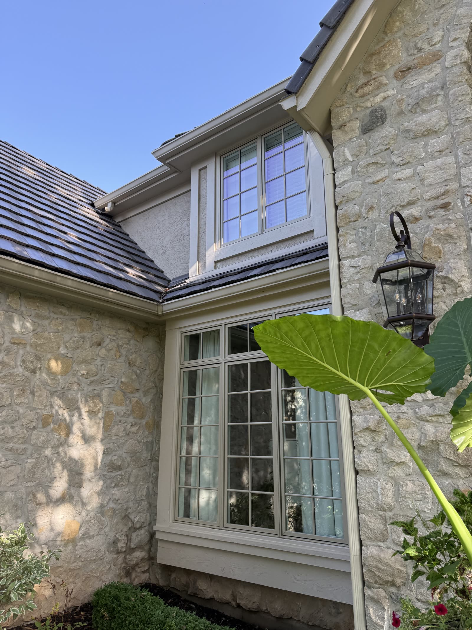Stone-front home with freshly cleaned divided-light windows and clean gutters