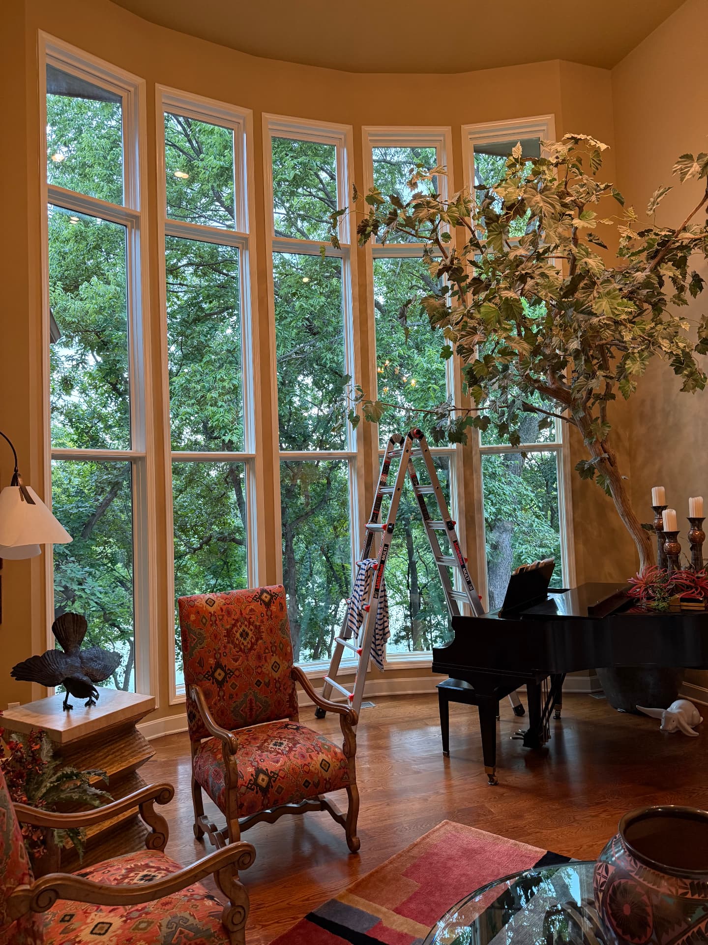 Two-story interior window wall cleaned above a grand piano