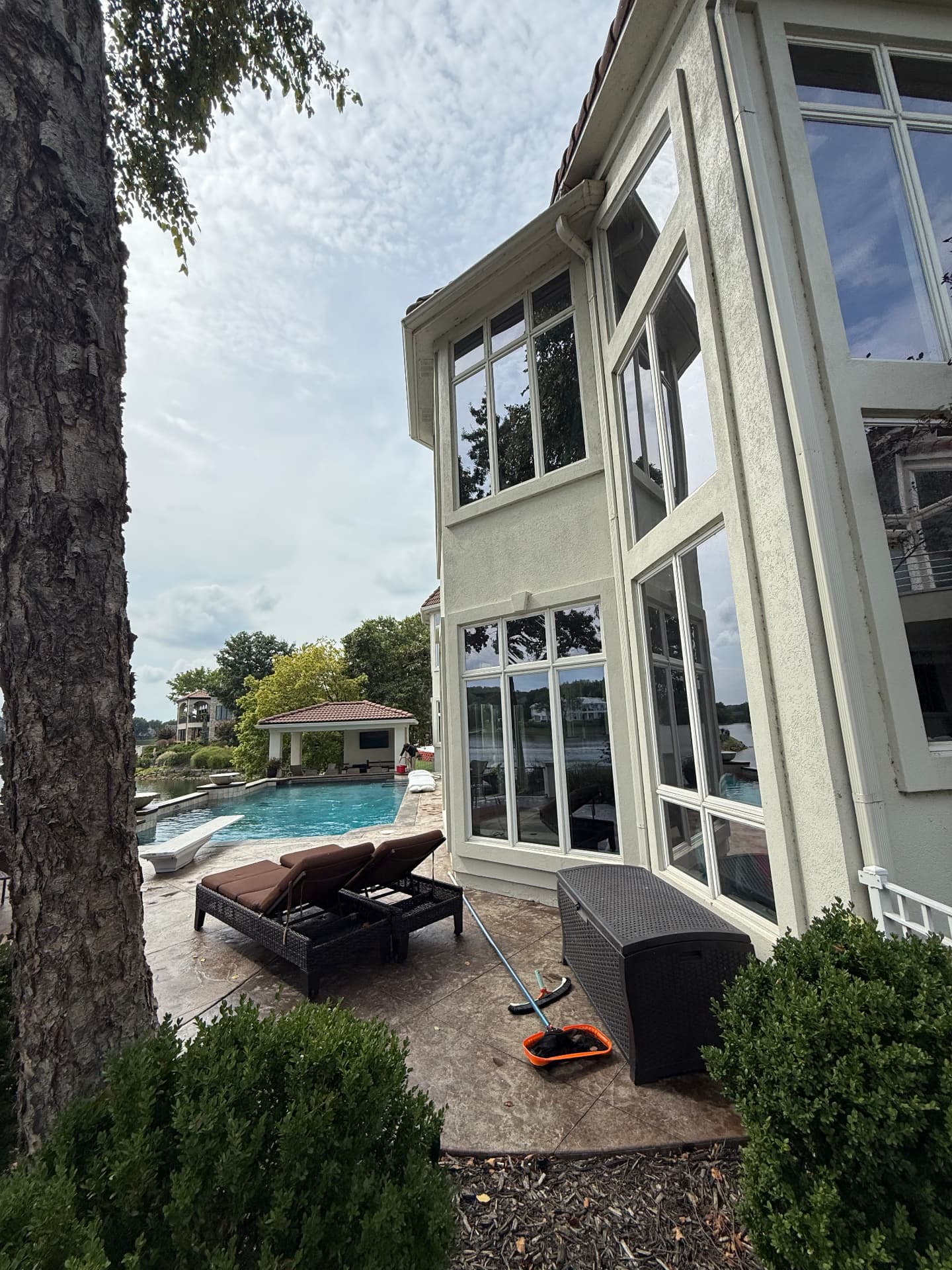 Water-fed pole and squeegee beside a lakefront home with freshly cleaned windows
